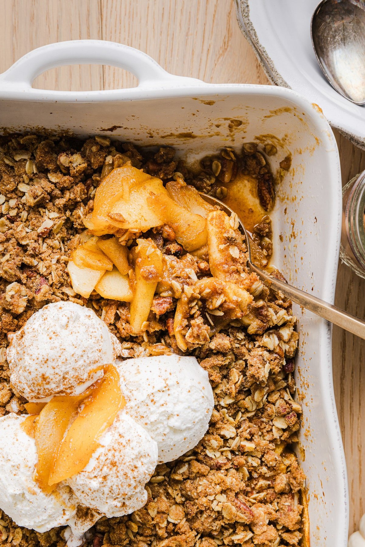 Apple pumpkin crisp in a baking dish with vanilla ice cream.