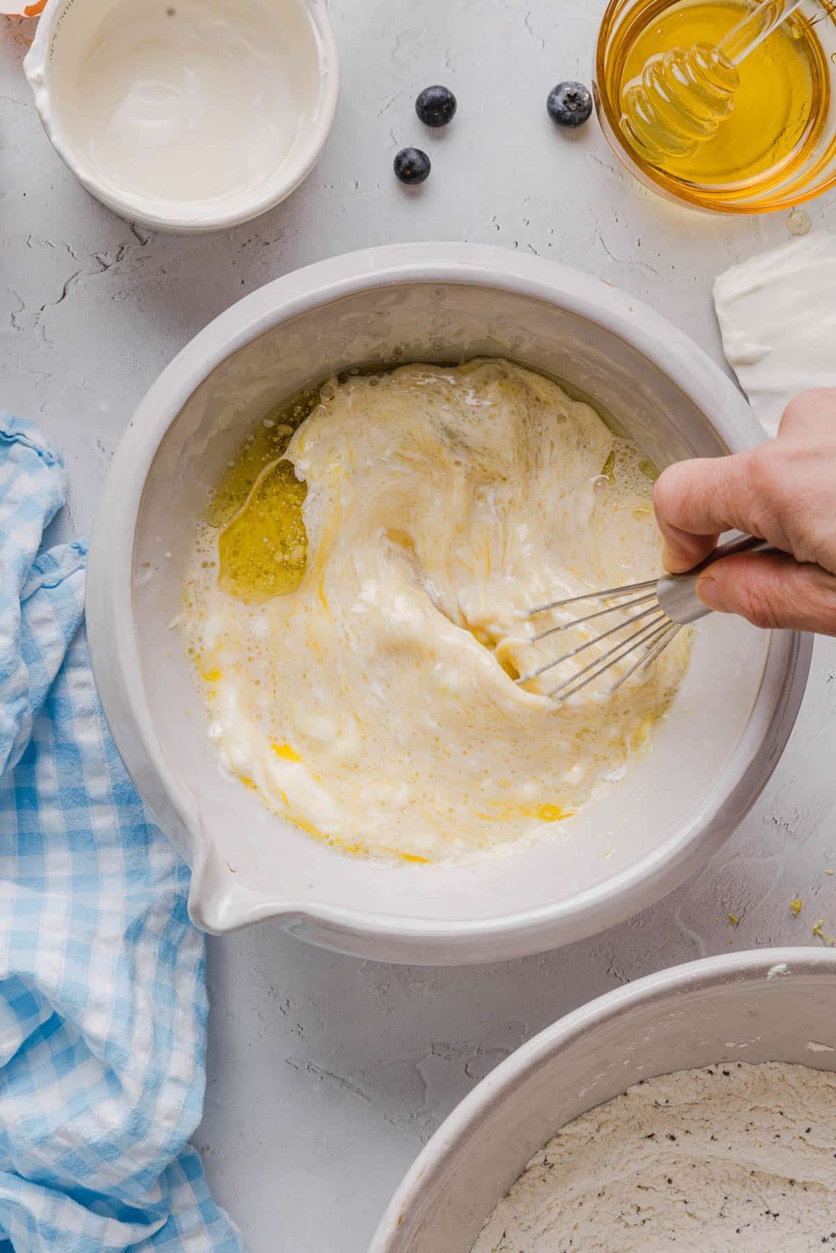 All of the wet ingredients whisked together in a white bowl on a white countertop.