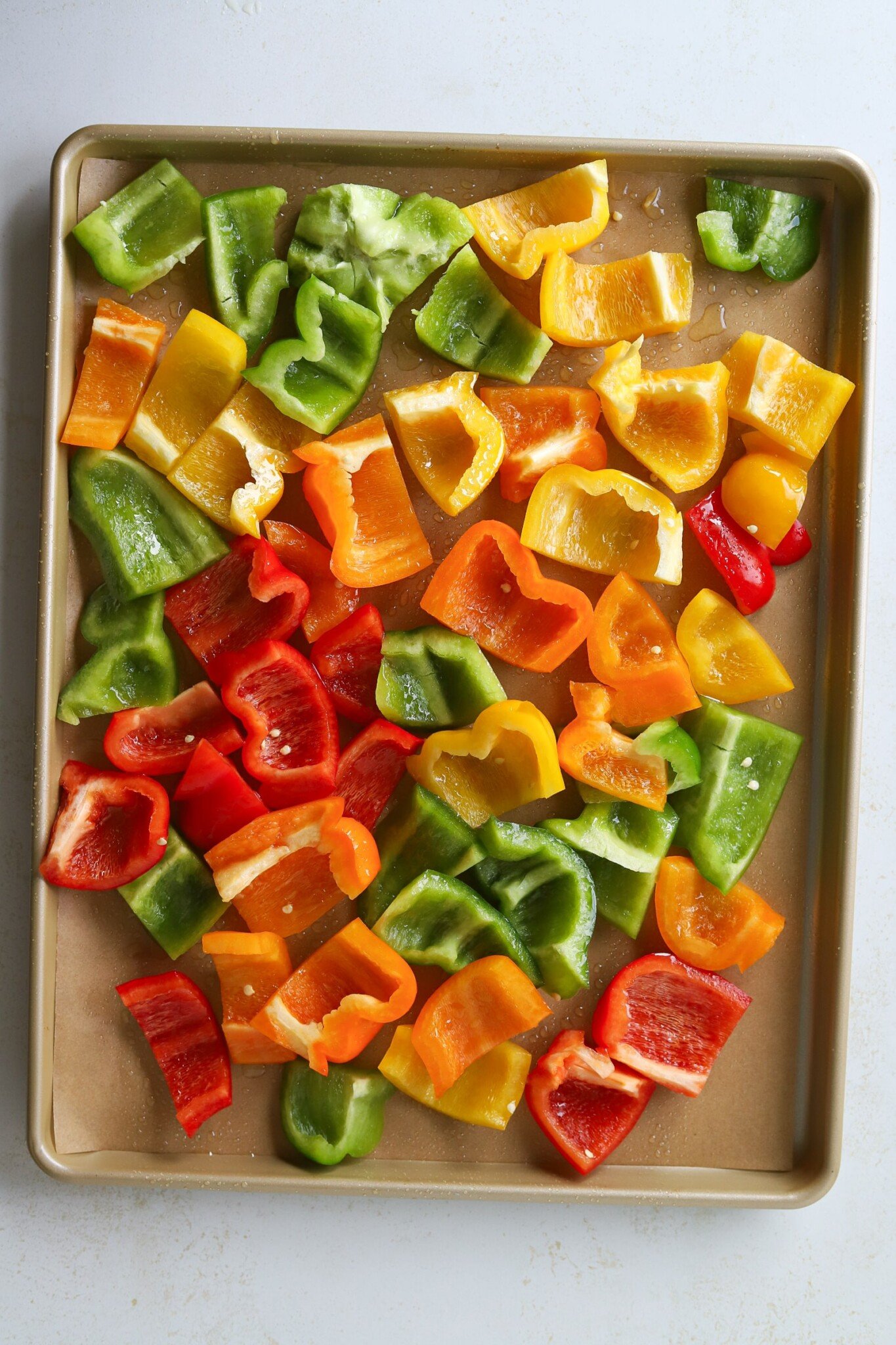 Bell pepper pieces on a lined sheet pan.