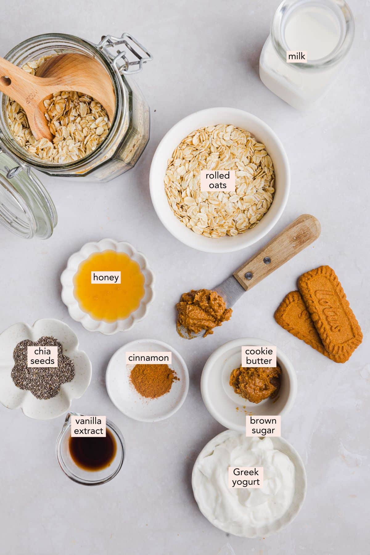 Ingredients for biscoff overnight oats on a countertop with labels.