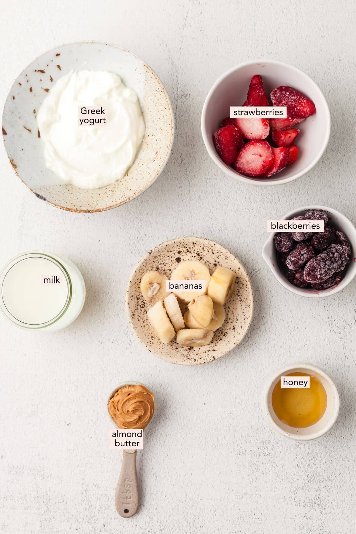 Ingredients for blackberry smoothie on a countertop with labels.
