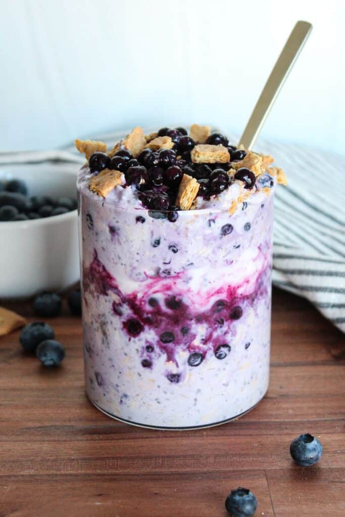 Blueberry cheesecake overnight oats topped with wild blueberries and graham crackers.