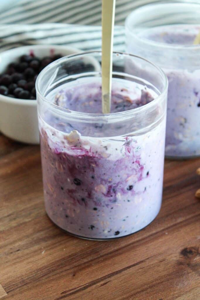 A jar with mixed blueberry cheesecake overnight oats.