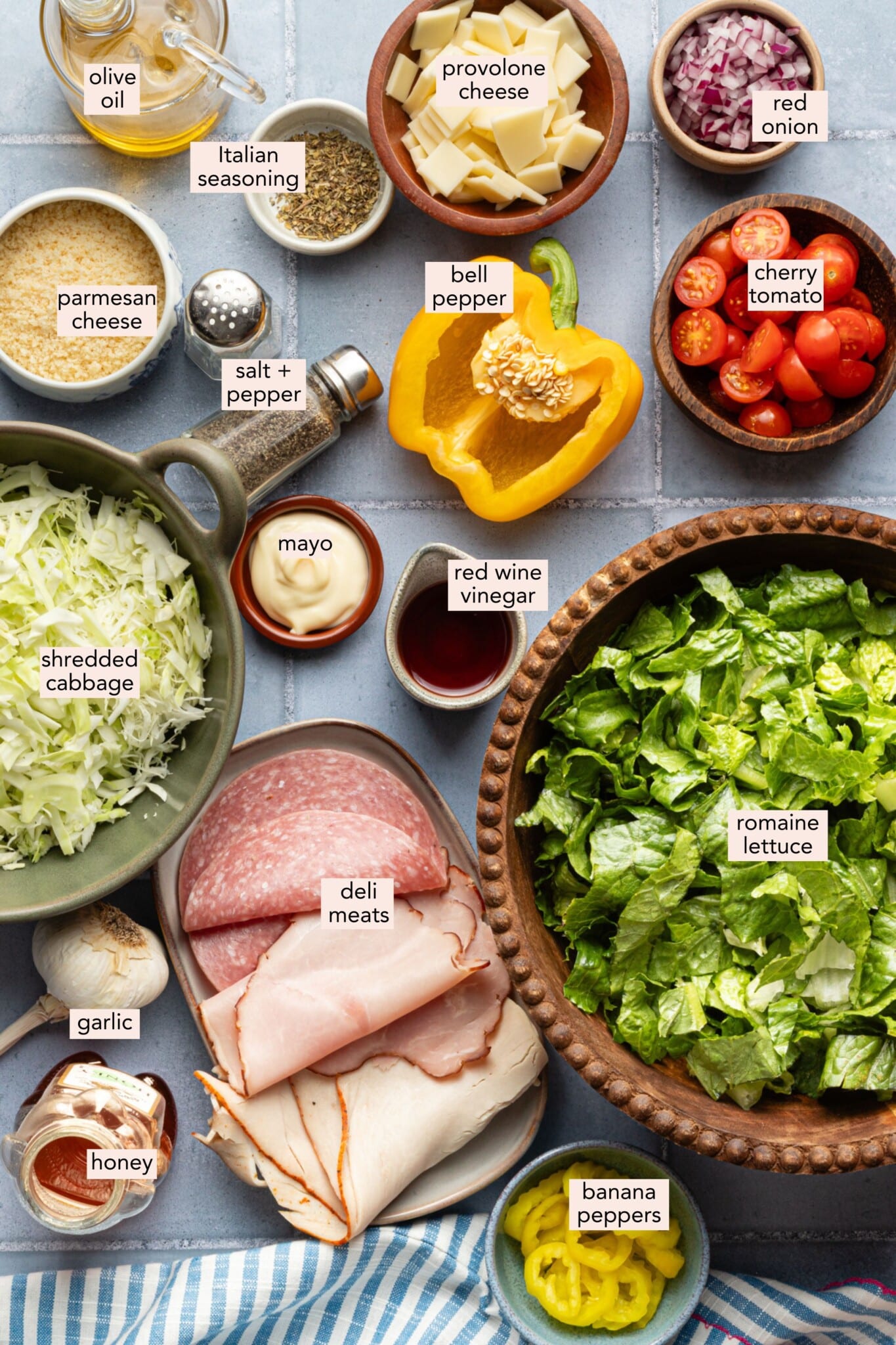 Grinder salad ingredients on a countertop with labels.