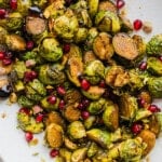 Roasted maple balsamic brussels sprouts topped with pomegranate seeds and pistachios.