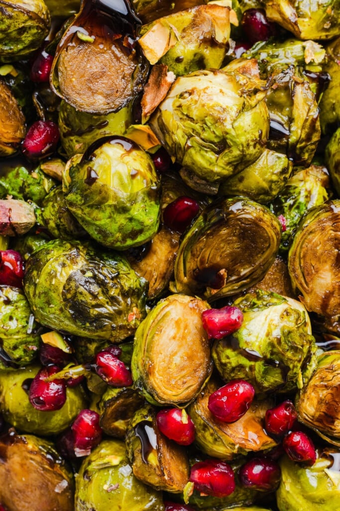 Roasted maple balsamic brussels sprouts topped with pomegranate seeds and pistachios.