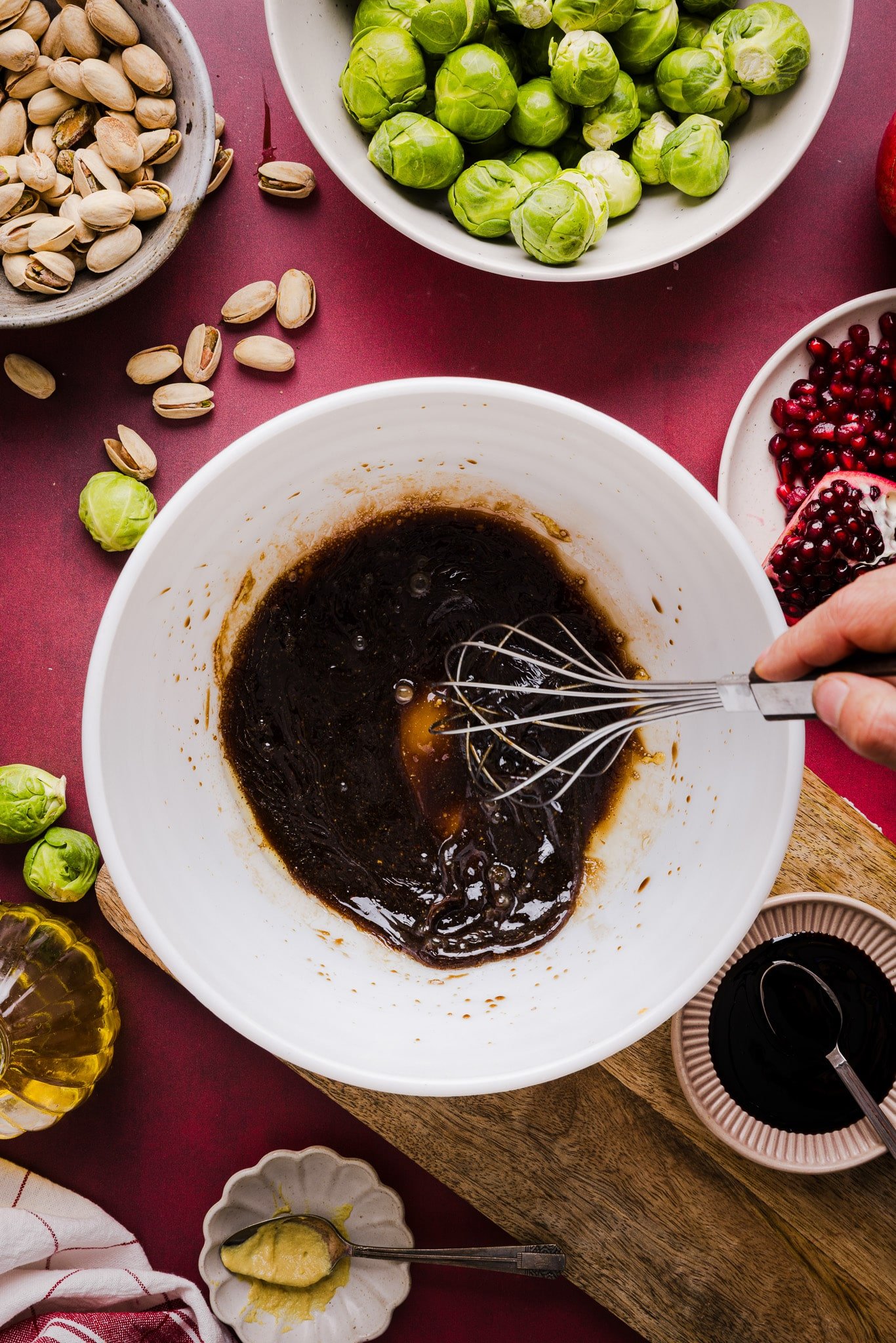Maple syrup, balsamic vinegar, soy sauce, garlic and oil being whisked together in a bowl.