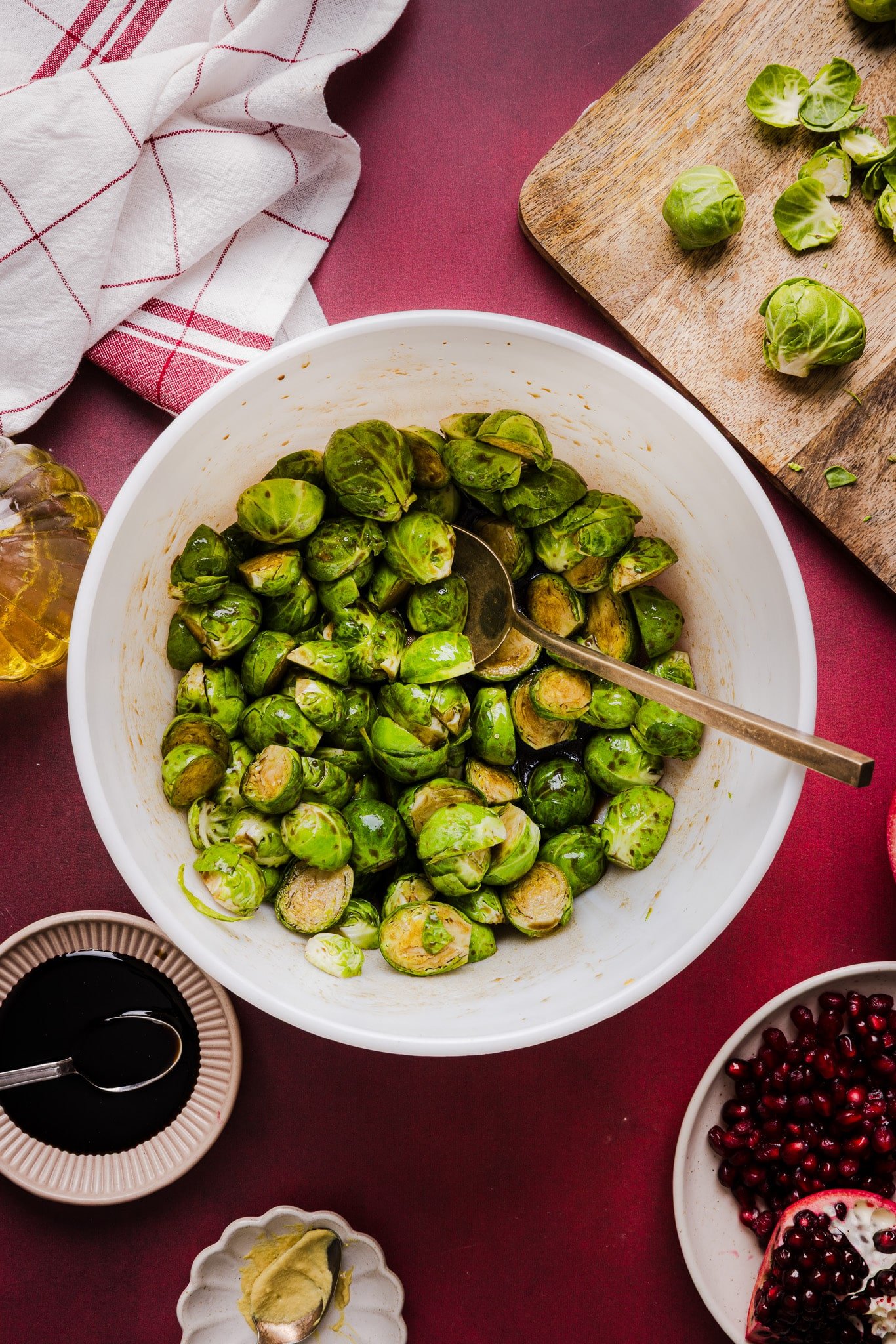 Brussels sprouts being tossed in a maple balsamic dressing.