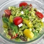 A clear bowl of pesto orzo salad.