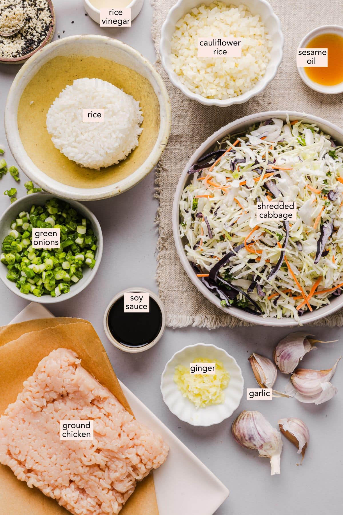 This is the BEST egg roll in a bowl recipe! It takes less than 20 min and uses one pan. An easy, satisfying dinner idea everyone loves. Ingredients for inside out egg roll bowl on a countertop with labels.