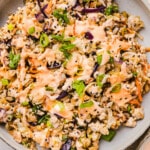 Inside out egg roll bowl in a plate with sriracha mayo on top.