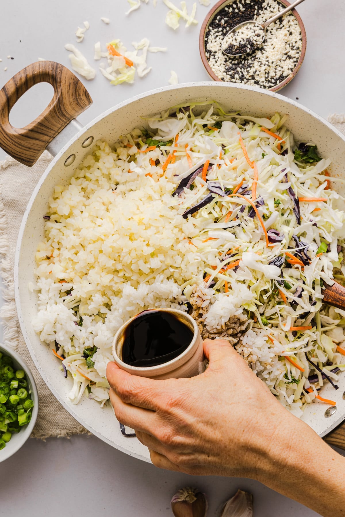 Cabbage and cauliflower being added to a pan for inside out egg roll.
