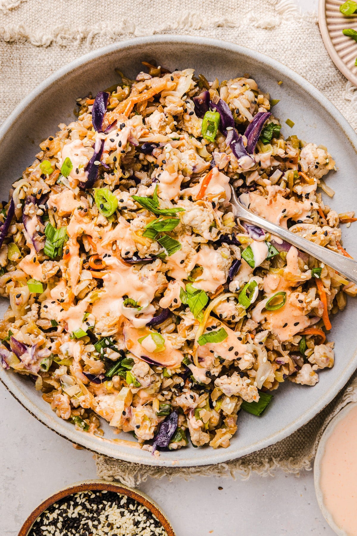 Inside out egg roll bowl topped with sriracha mayonnaise.