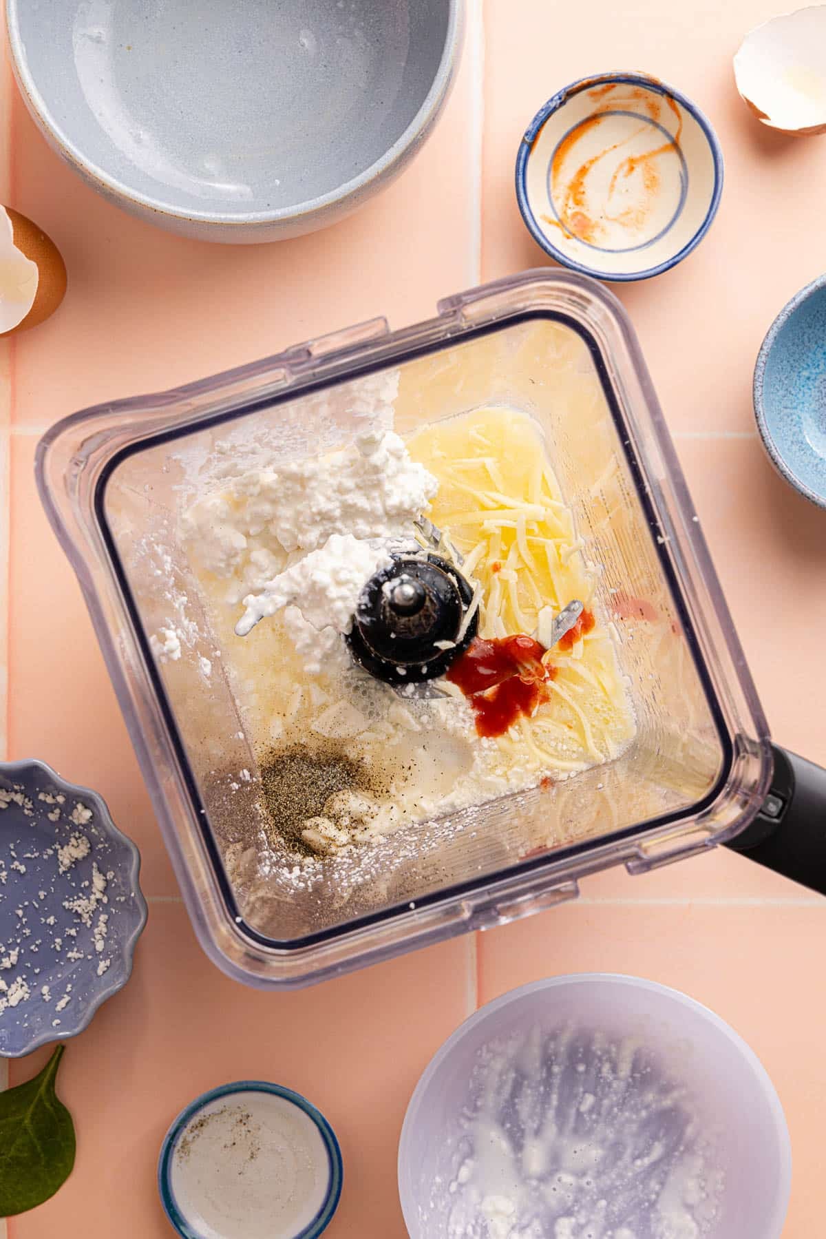 The egg whites, cottage cheese, monterey jack cheese, feta chese, hot sauce, cornstarch, salt and pepper in a blender before blending.