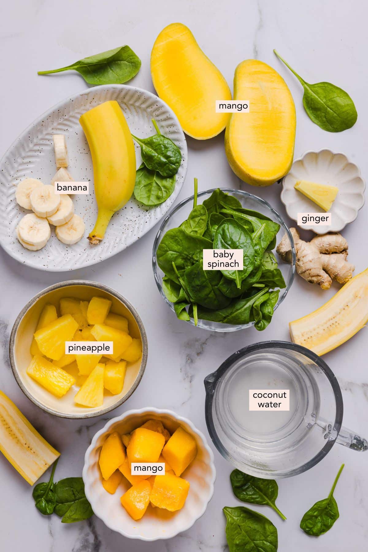 Ingredients for tropical smoothie detox island green copycat recipe on a countertop with labels.