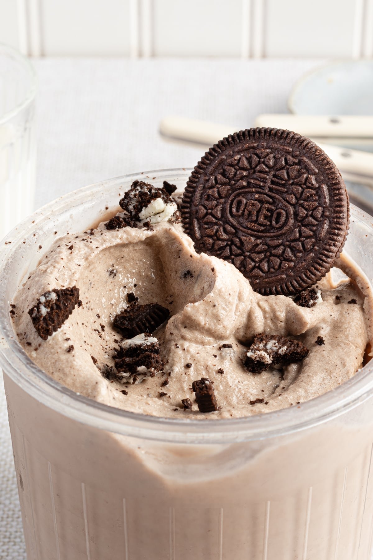 Ninja creami cookies and creami ice cream in a pint container topped with Oreos.