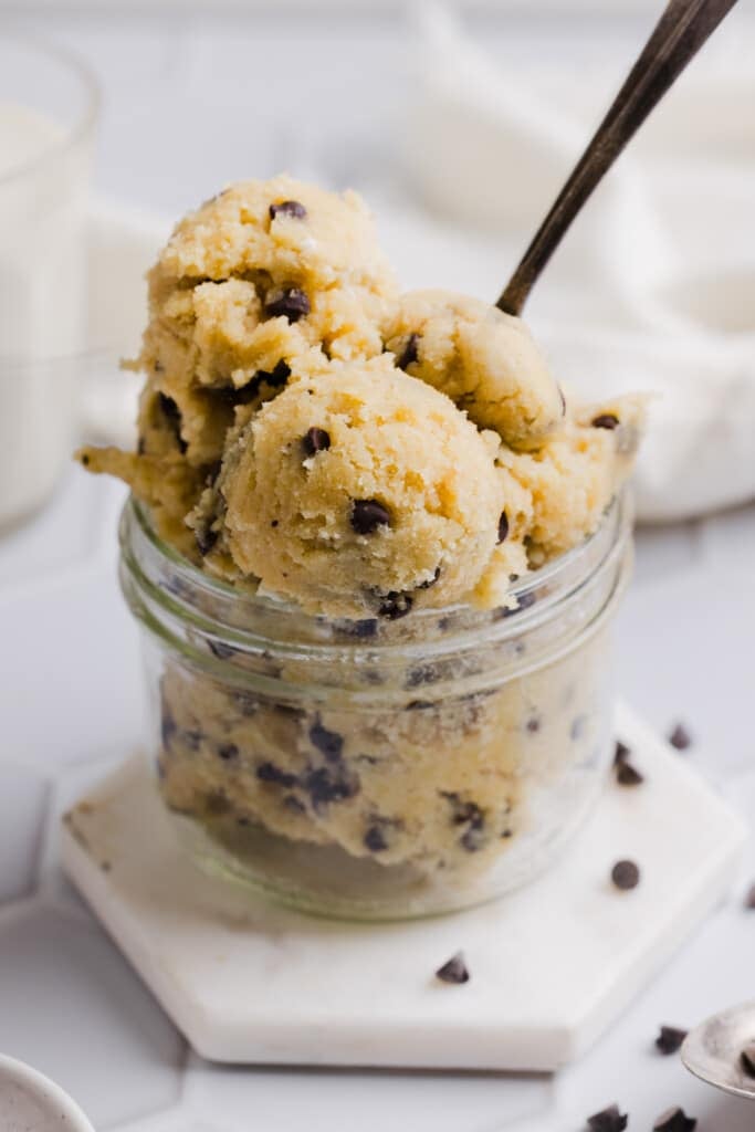 Cottage cheese cookie dough scooped into a mason jar with a spoon.