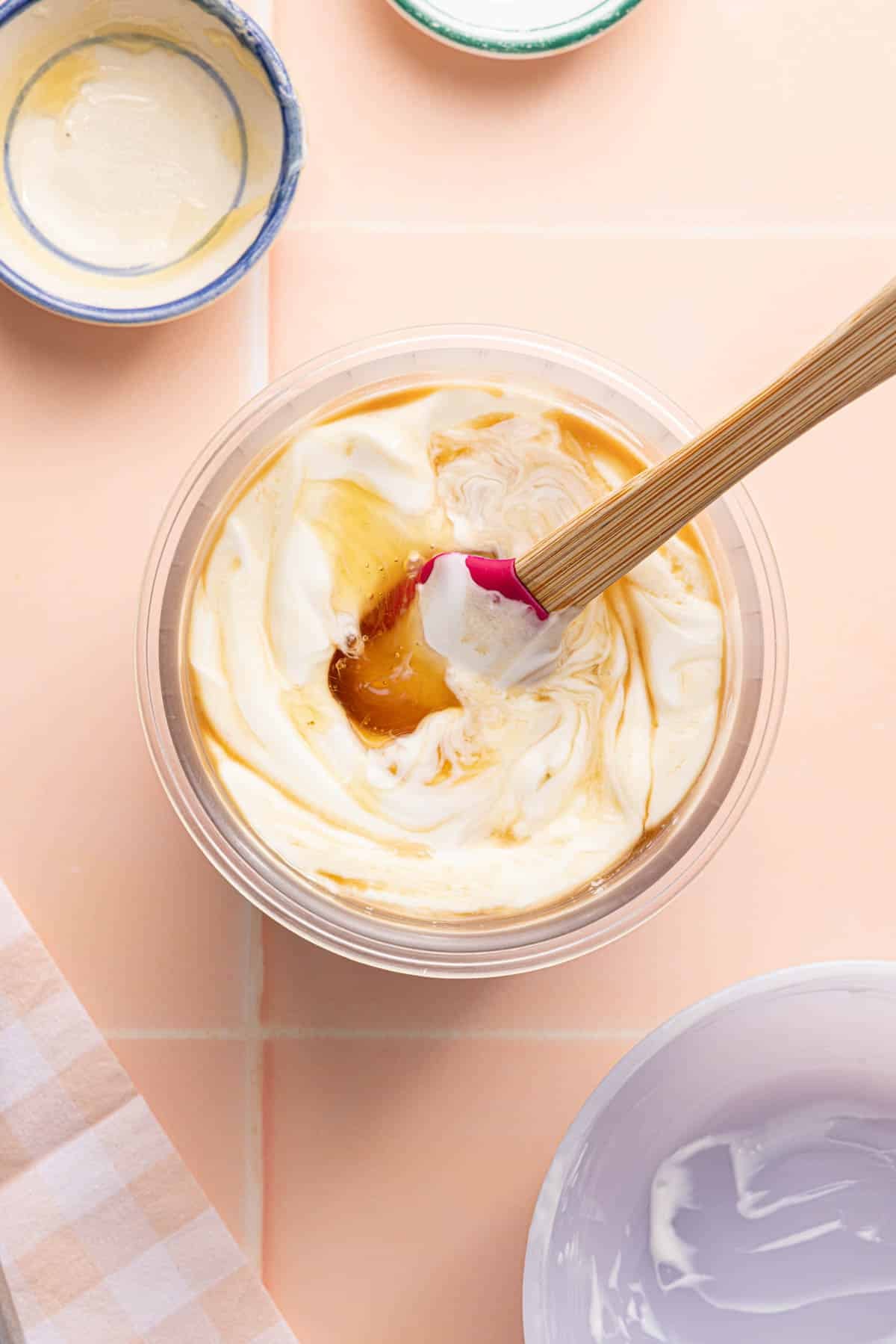 The yogurt, vanilla, and honey in a ninja creami container on a countertop.