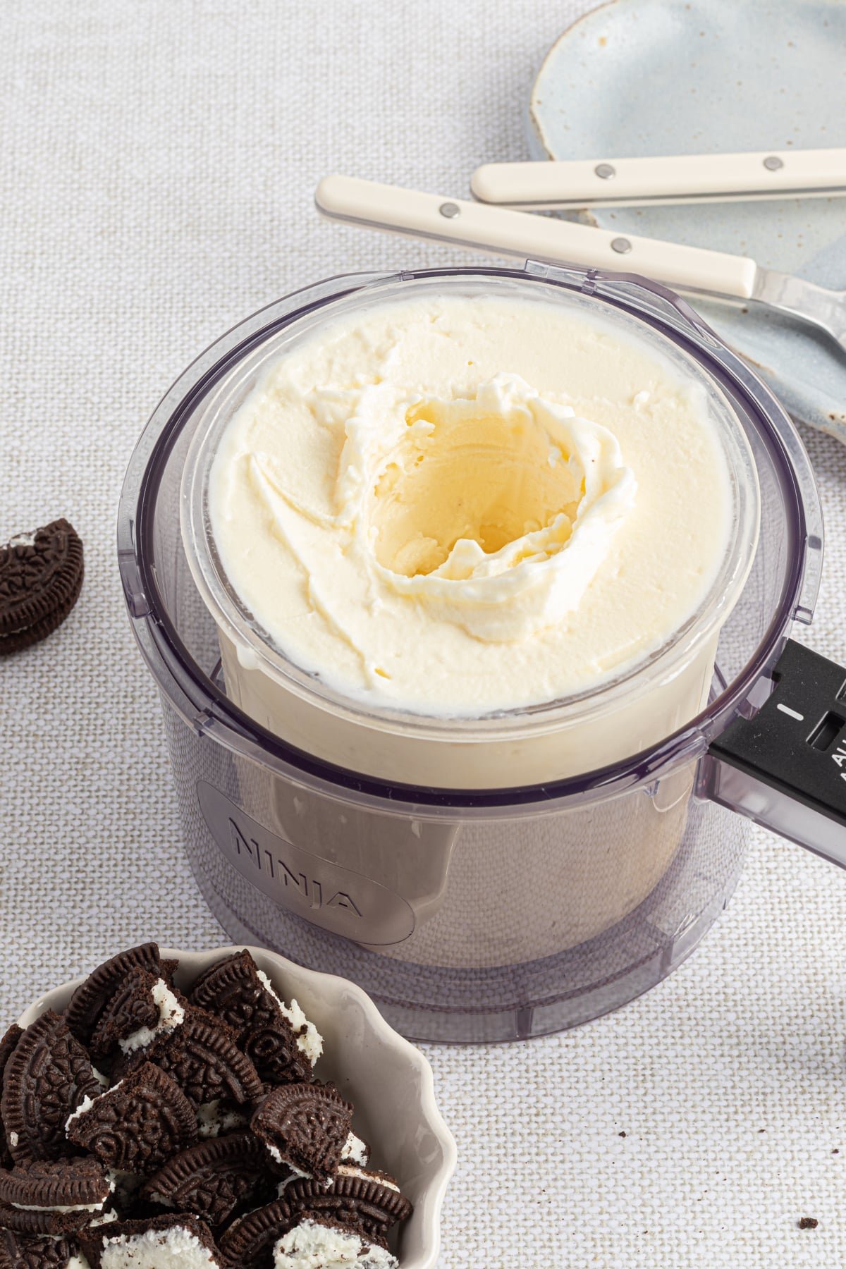 Vanilla ice cream with a hole in the center in the ninja creami pint container ready for mix-ins.