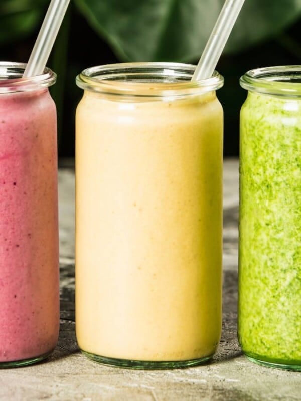 Smoothies lined up in a row in glass cups.