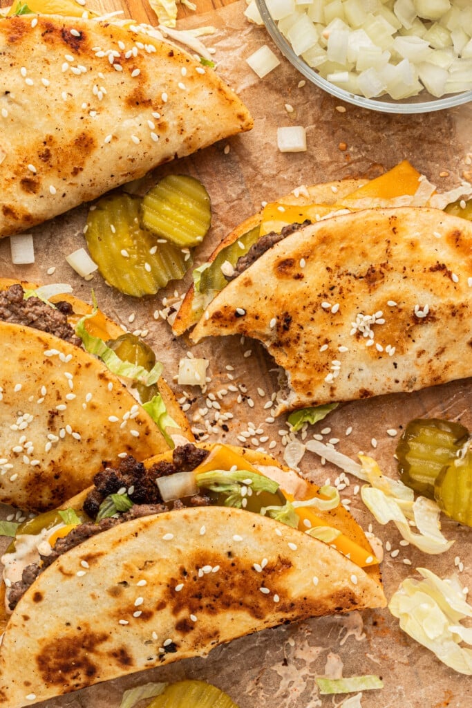 Big Mac tacos on a parchment paper garnished with sesame seeds and pickles