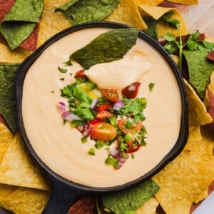 Cottage cheese quest garnished with cilantro, red onion and tomato with tortilla chips.