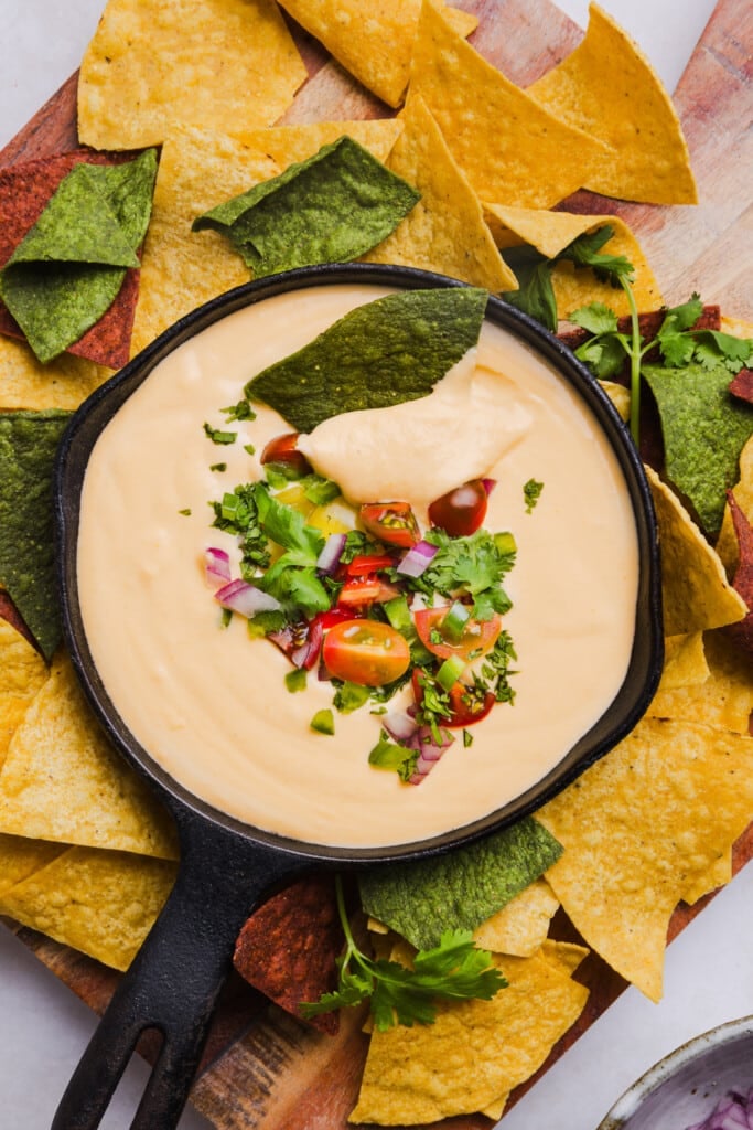 Cottage cheese quest garnished with cilantro, red onion and tomato with tortilla chips.