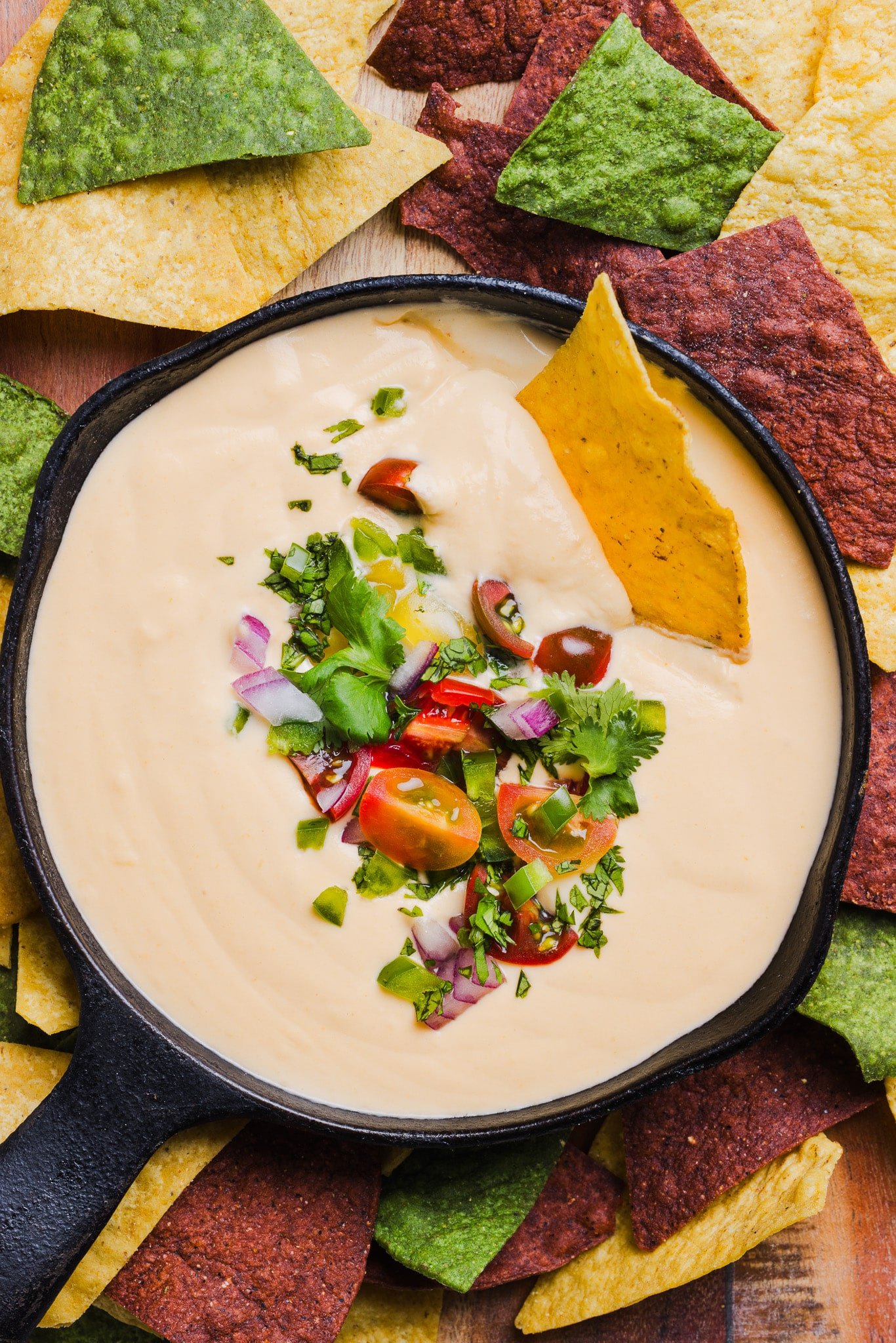 Cottage cheese quest garnished with cilantro, red onion and tomato with tortilla chips.