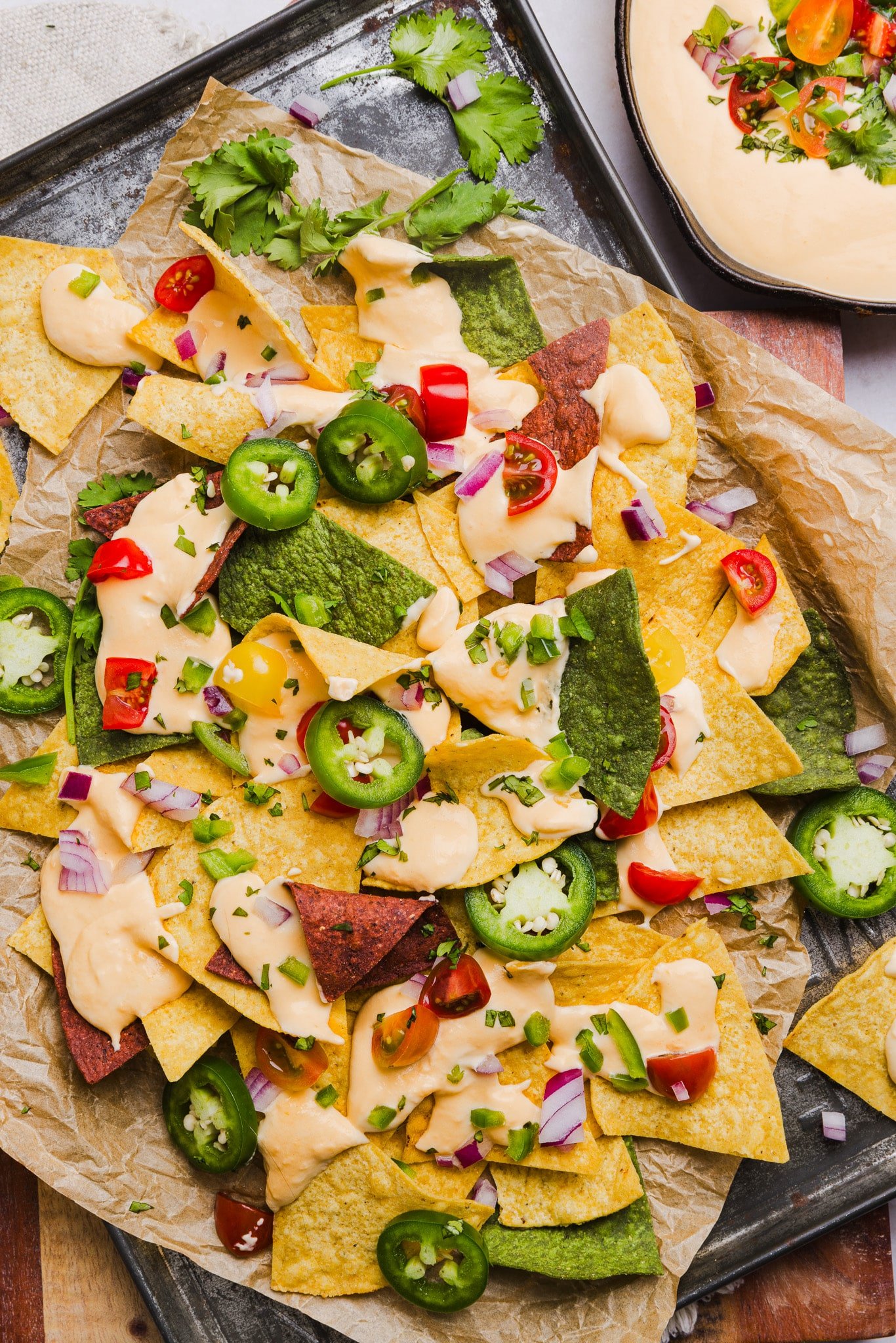 Cottage cheese queso drizzled on top of nachos.