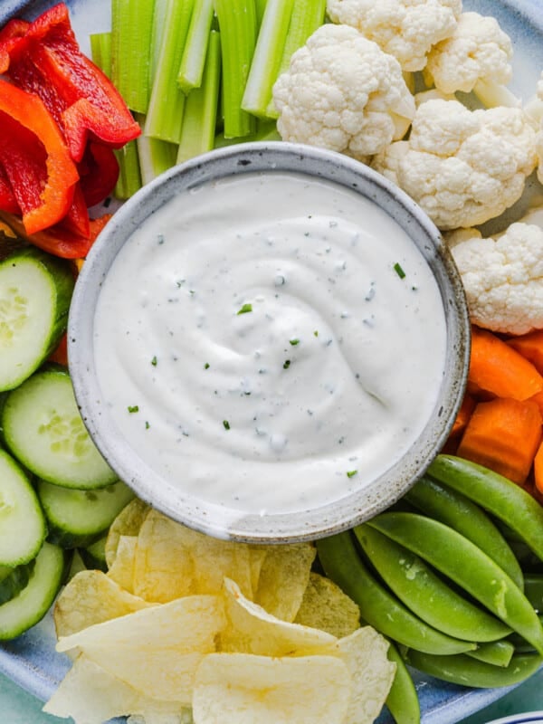 Ranch dip with cottage cheese in a bowl on a vegetable plate with various cut vegetables.