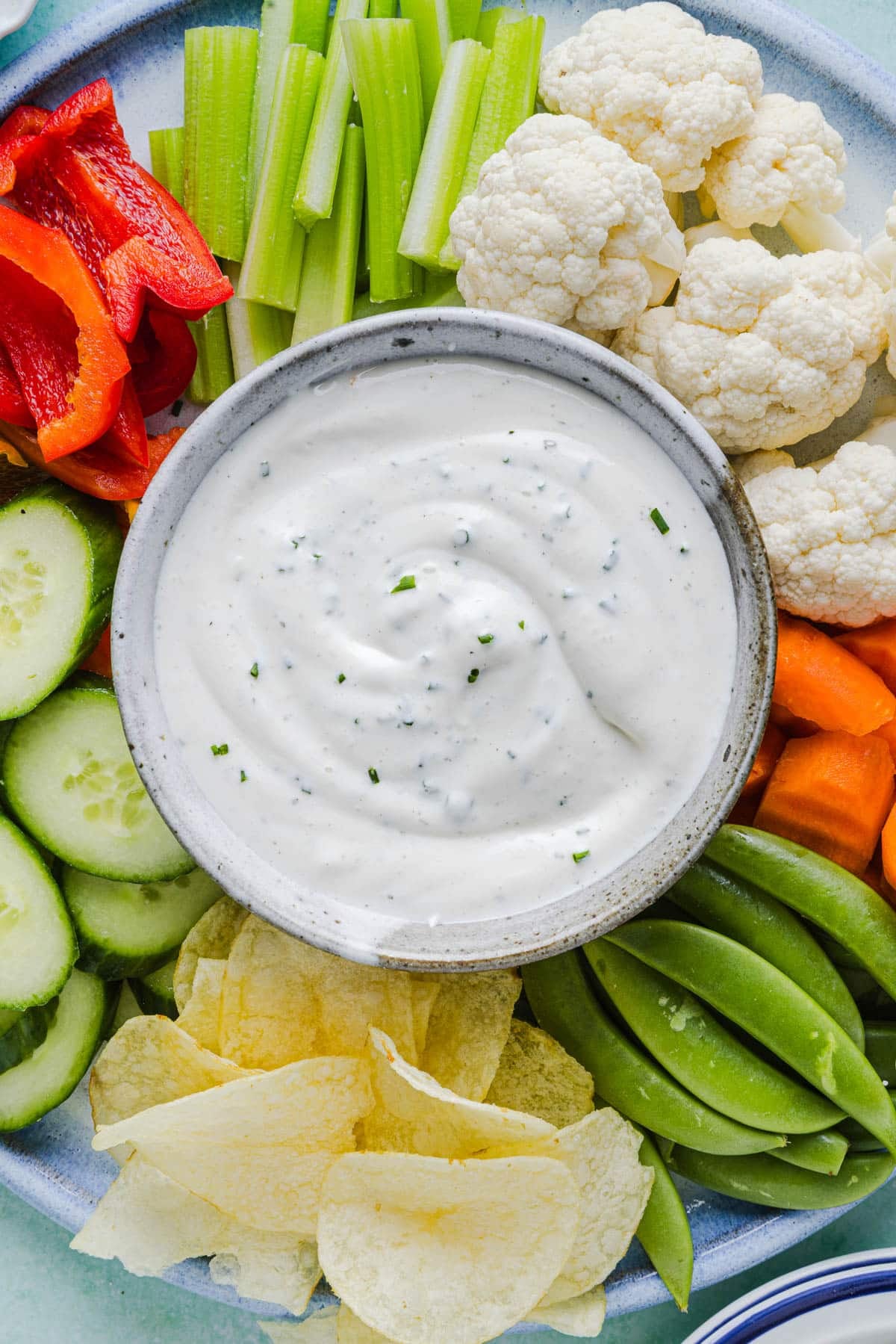 Ranch dip with cottage cheese in a bowl on a vegetable plate with various cut vegetables.
