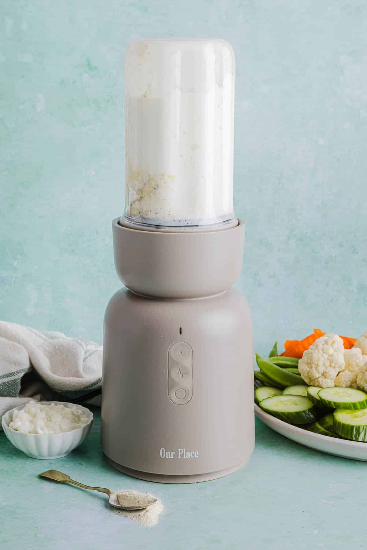 The cottage cheese and ranch seasoning mix blended in a blender on a countertop.