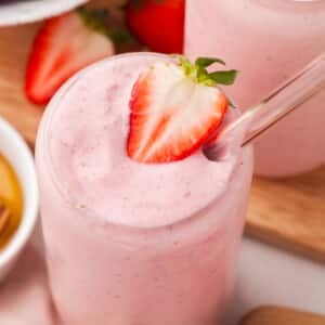A close up shot of cottage cheese smoothie garnished with a slice of strawberry.