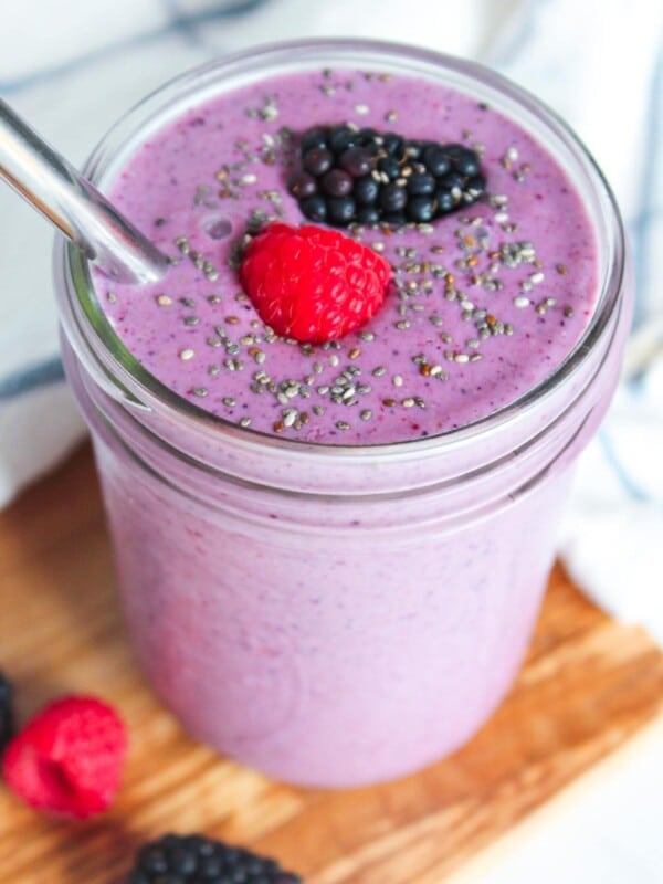 A high fiber smoothie with mixed berries, chia seeds and banana sprinkled with chia seeds and berries on top.