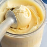 A Ninja Creami pint container full of protein ice cream with an ice cream scoop.