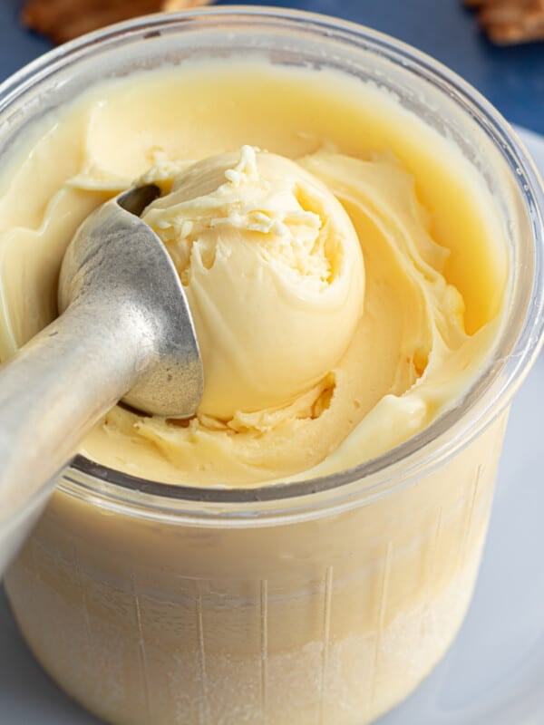 A Ninja Creami pint container full of protein ice cream with an ice cream scoop.