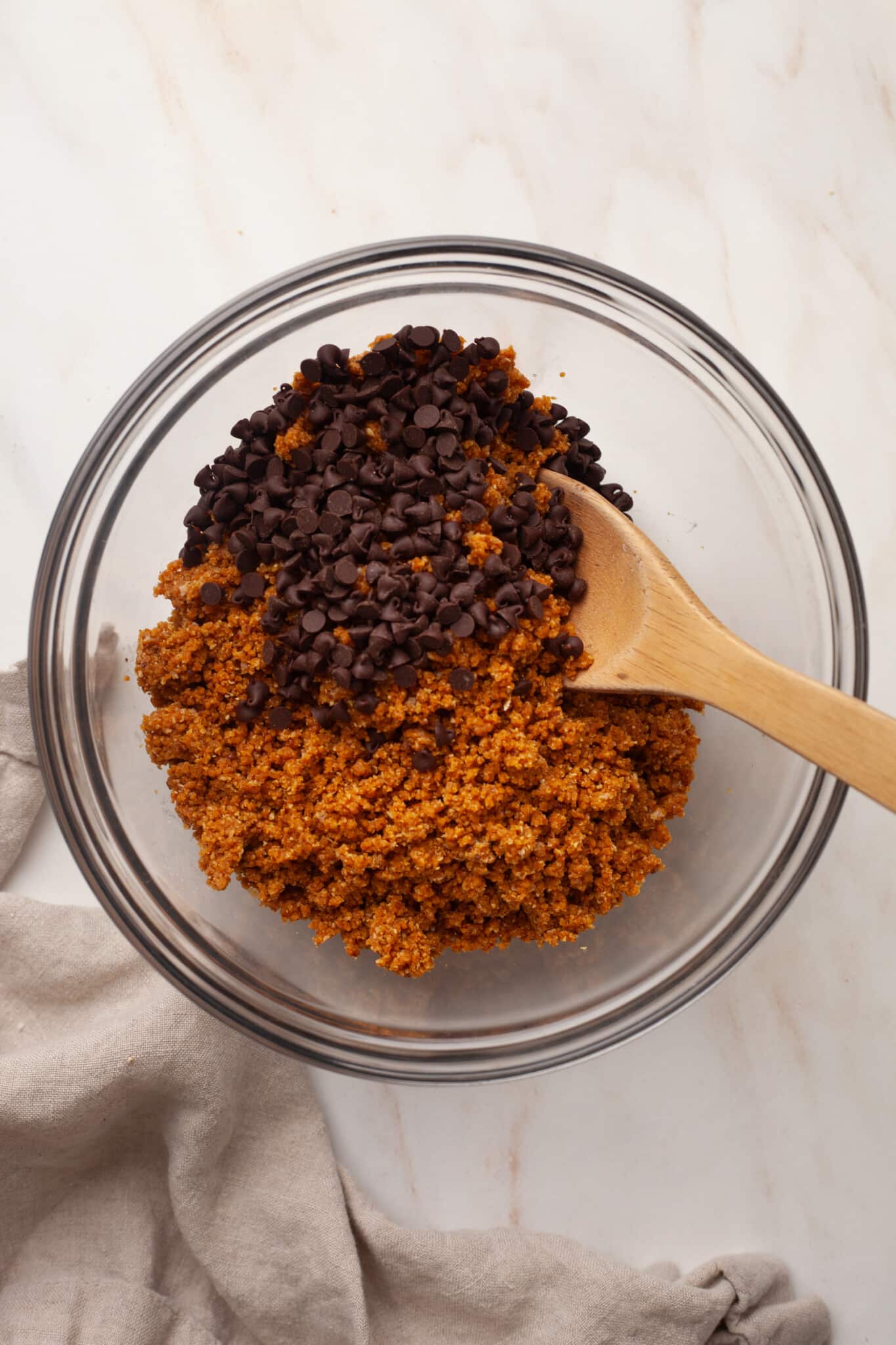Mini chocolate chips being added to pumpkin protein ball mixture.