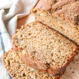 A loaf of chia seed banana bread with brown sugar cinnamon topping being sliced.