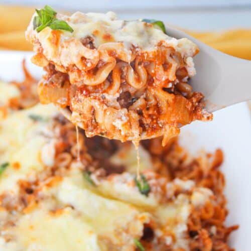 A close up shot of a scoop of deconstructed lasagna on a serving spoon.