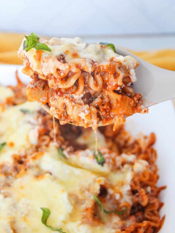 A close up shot of a scoop of deconstructed lasagna on a serving spoon.
