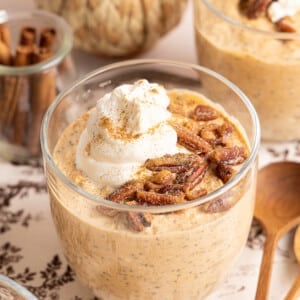 Pumpkin overnight oats in a jar topped with pecans, cinnamon, and a dollop of yogurt.