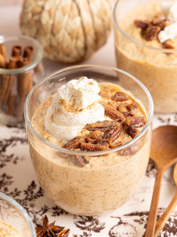 Pumpkin overnight oats in a jar topped with pecans, cinnamon, and a dollop of yogurt.
