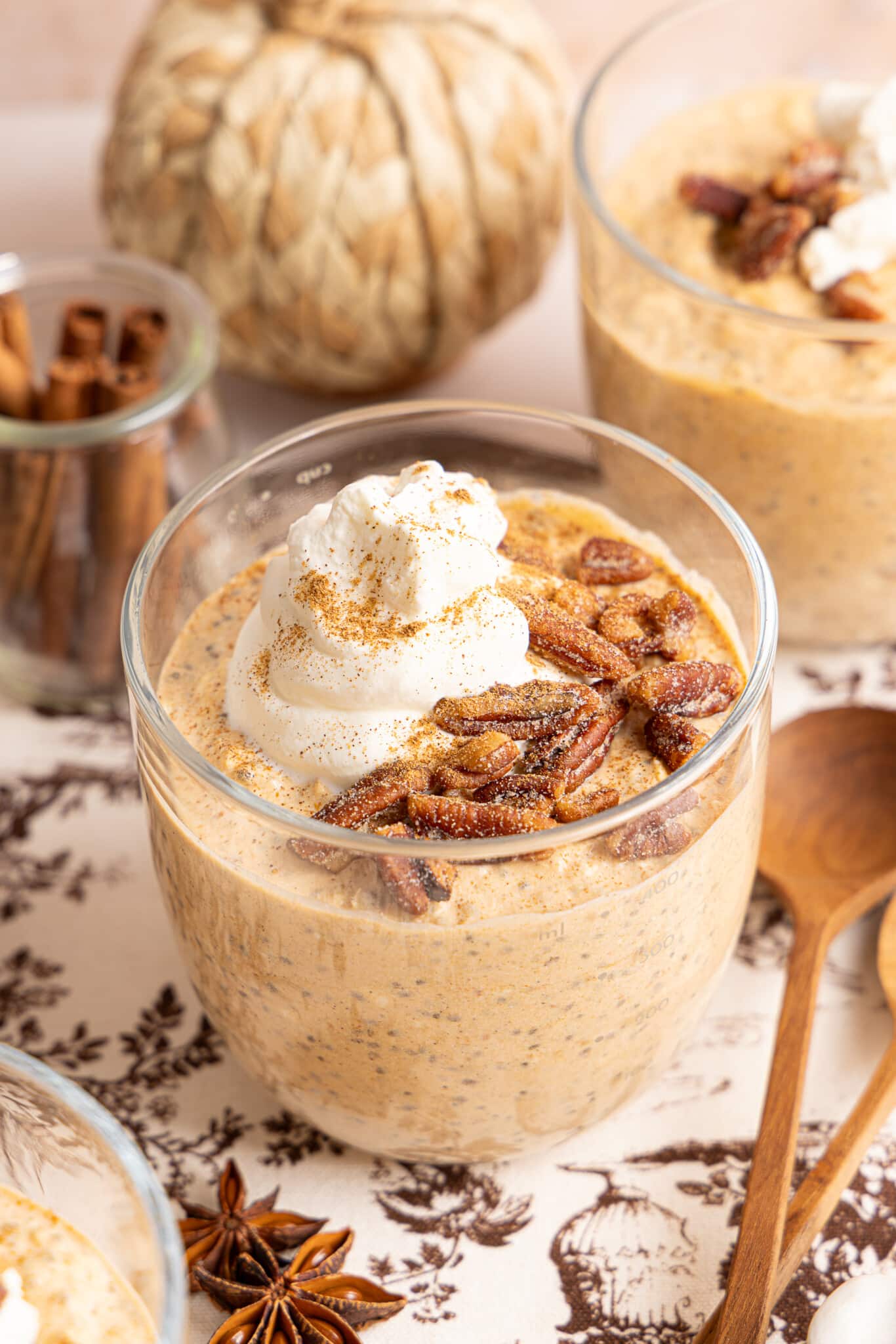 Pumpkin overnight oats in a jar topped with pecans, cinnamon, and a dollop of yogurt.