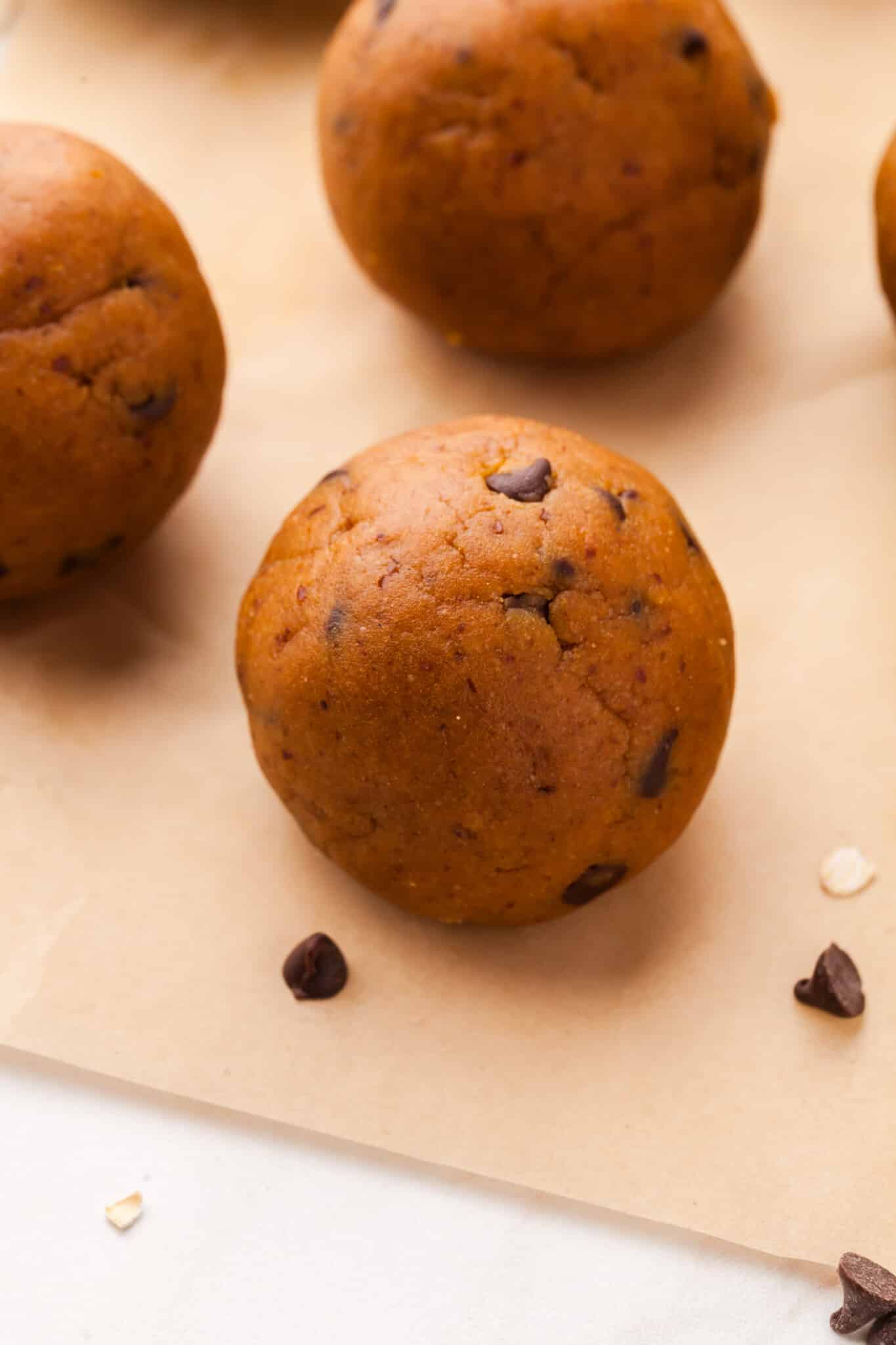 A close up shot of a protein pumpkin ball on parchment paper.