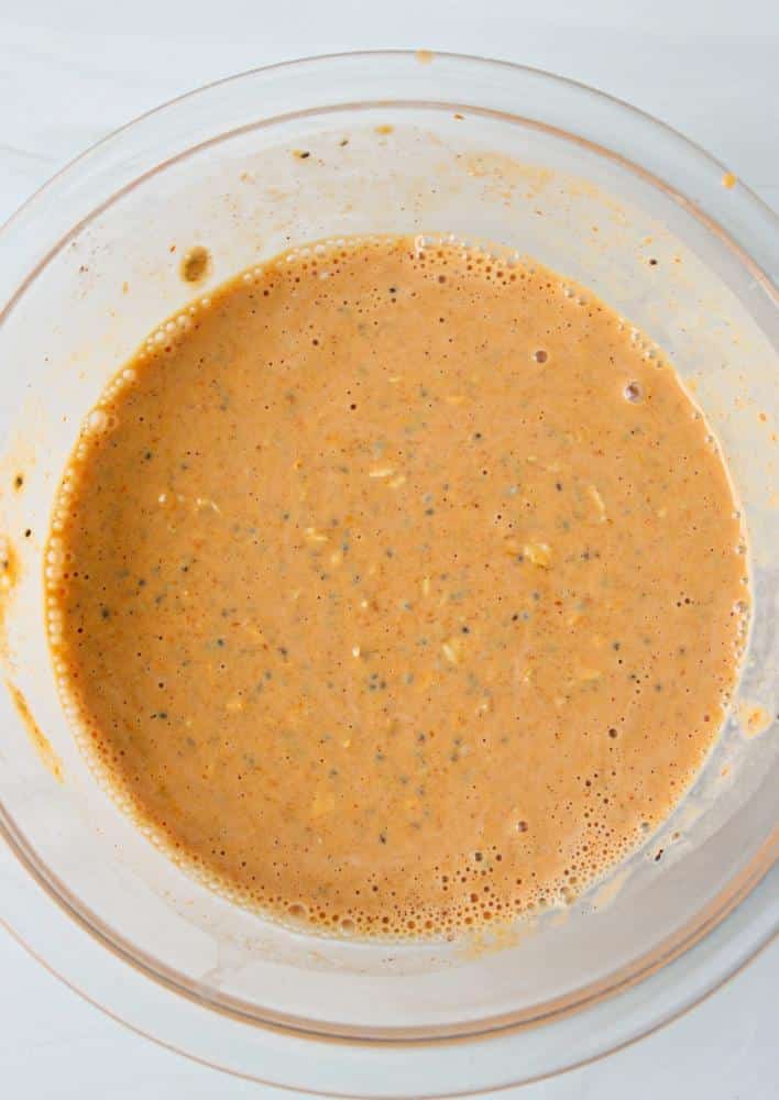 A clear bowl full of mixed pumpkin spice oatmeal ingredients.