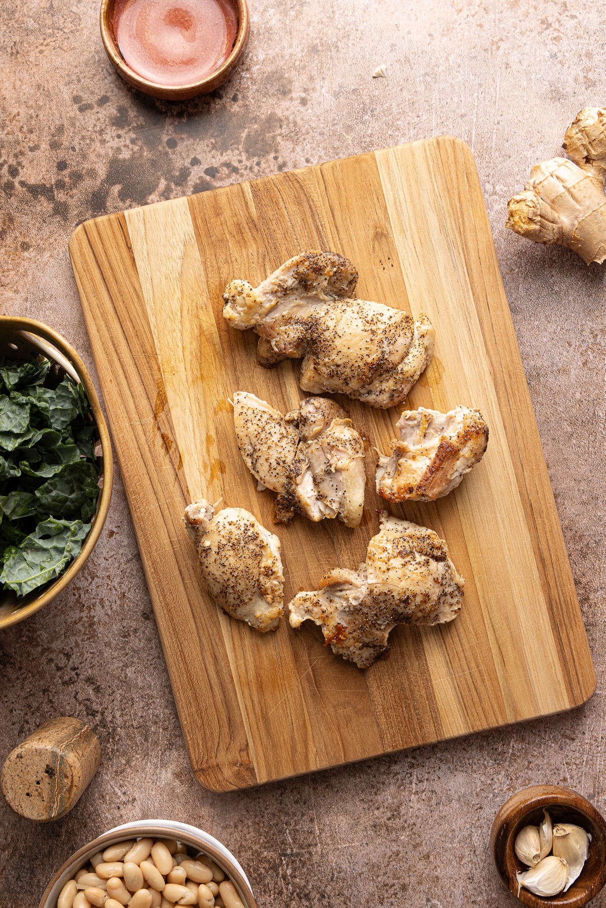 The cooked chicken on a cutting board before cutting into small pieces.