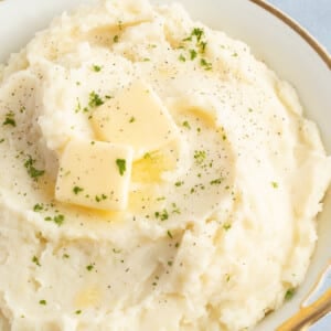 Cottage cheese mashed potatoes in a large bowl topped with butter.