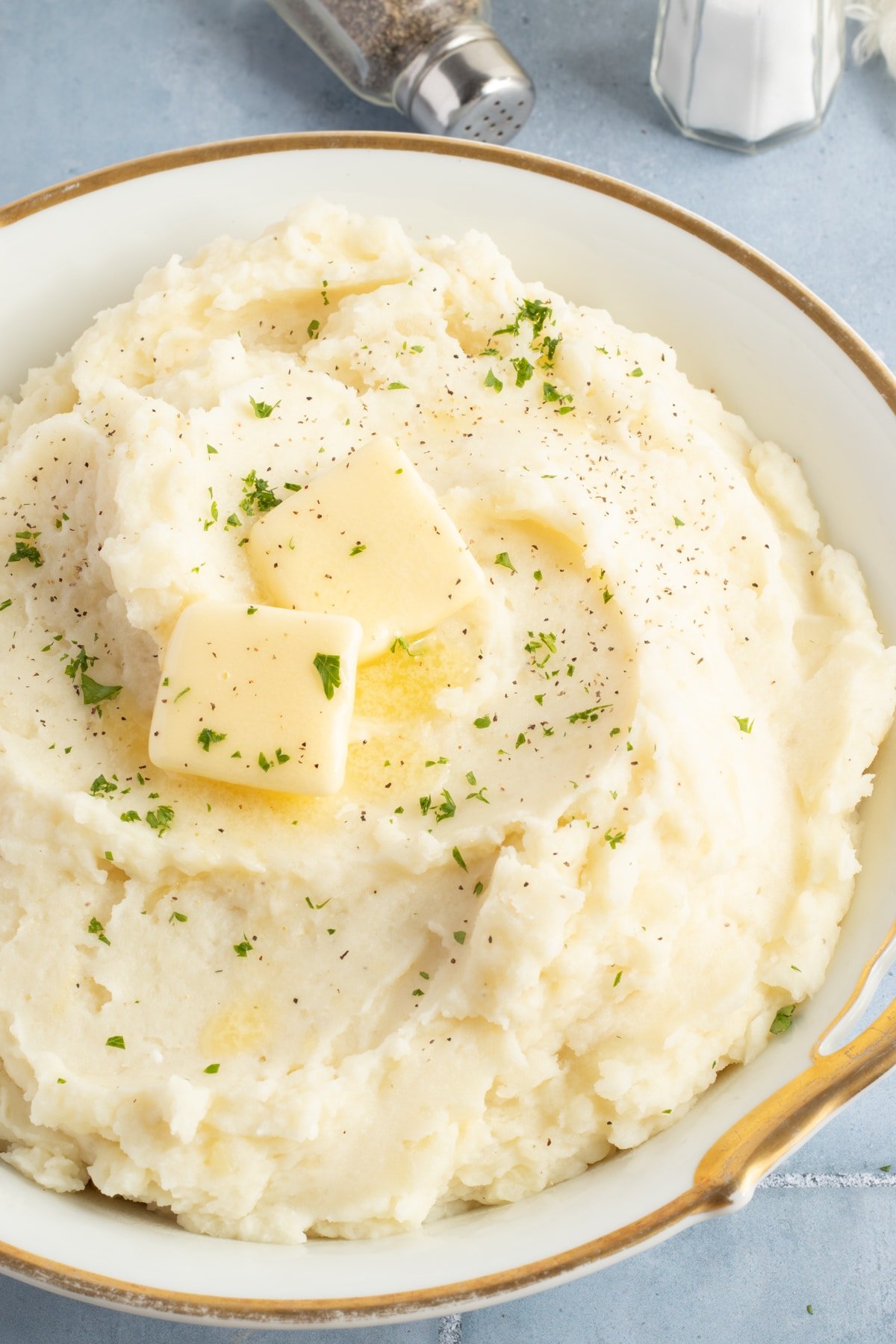 Cottage cheese mashed potatoes in a large bowl topped with butter.