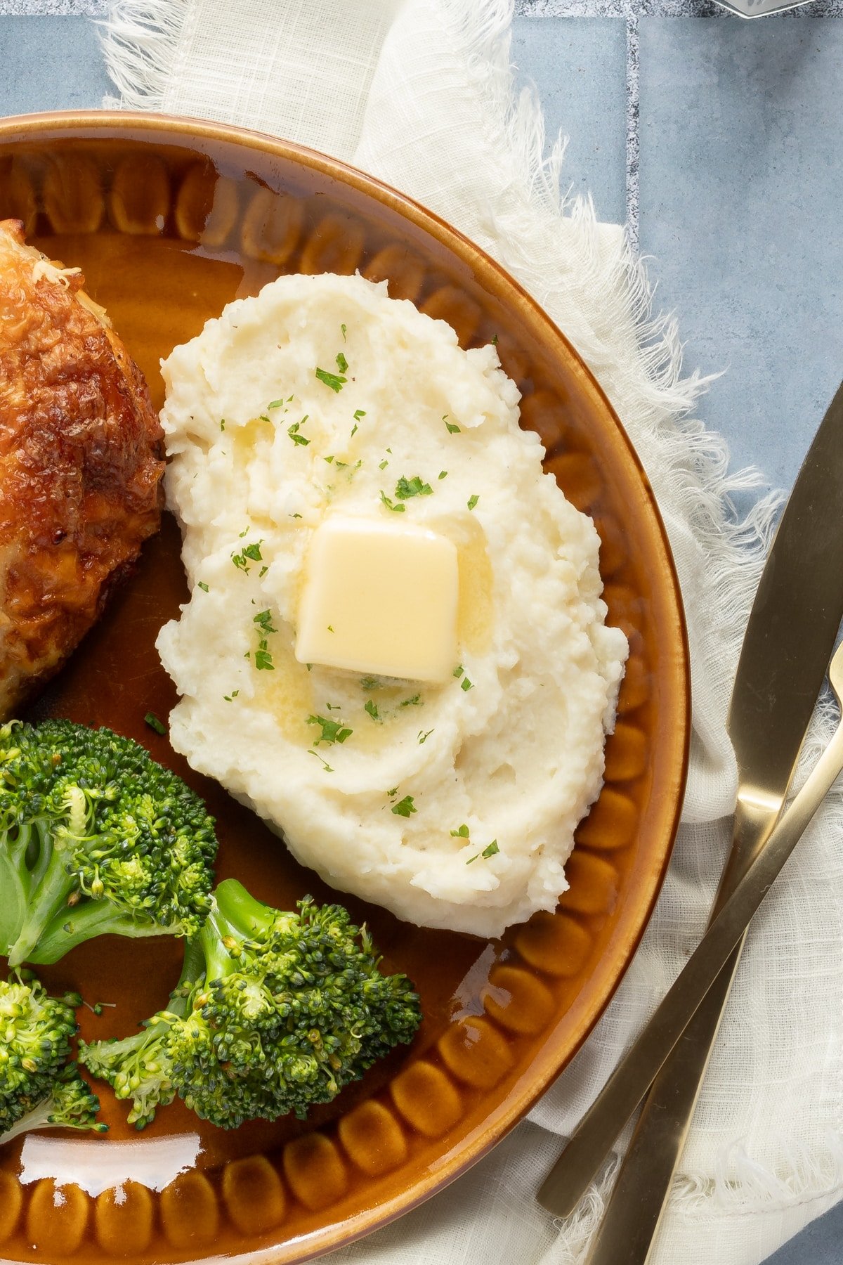 Cottage cheese mashed potatoes on a plate with chicken and broccoli.