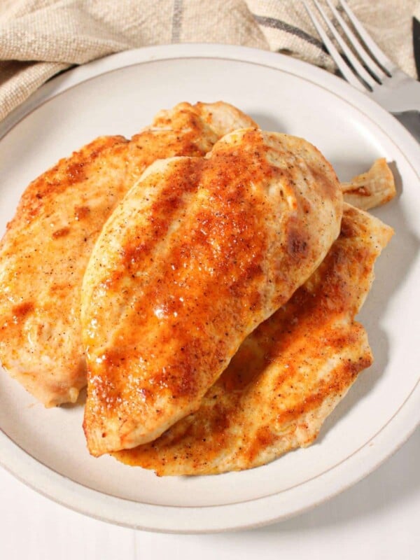 Thinly sliced chicken breast piled on a plate.